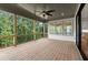 Spacious covered patio features a ceiling fan and black railings, offering a great view of nature at 6750 Pannell Rd, Buford, GA 30518