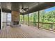 Covered porch with stone fireplace and wood ceiling overlooking a wooded backyard at 6750 Pannell Rd, Buford, GA 30518