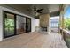 Covered patio boasts a stone fireplace, ceiling fan, and sliding glass doors to the interior at 6750 Pannell Rd, Buford, GA 30518