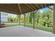 Covered outdoor patio space with wood support beams and a view of the grassy backyard at 6750 Pannell Rd, Buford, GA 30518