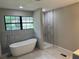 Modern bathroom featuring a soaking tub, separate shower, and large window at 1516 Chase Ct, Riverdale, GA 30296