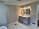 Bathroom with a gray double vanity, two mirrors, and modern lights at 1516 Chase Ct, Riverdale, GA 30296
