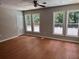 Spacious room with multiple large windows and backyard views, wood floors, and a ceiling fan at 1516 Chase Ct, Riverdale, GA 30296