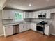 Bright kitchen with white cabinets, stainless steel appliances, and stone countertops at 1516 Chase Ct, Riverdale, GA 30296