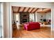 Inviting living room featuring exposed wood beams, hardwood floors, and a stone fireplace at 1516 Chase Ct, Riverdale, GA 30296