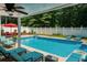 Outdoor pool area with seating, a red umbrella, and lush greenery at 1516 Chase Ct, Riverdale, GA 30296