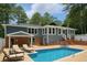 Back exterior of a home with a pool, lounge chairs, and a patio seating area, perfect for outdoor relaxation at 1516 Chase Ct, Riverdale, GA 30296
