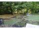 Landscaped backyard features a stone walkway, mini golf, and mature trees at 3199 Nw Delmar Ln, Atlanta, GA 30311