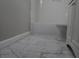 Close up of bathroom with gray marble tiled floor, white subway tile in shower, and white vanity at 3199 Nw Delmar Ln, Atlanta, GA 30311