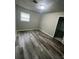 A freshly painted bedroom has sleek and stylish wood-look floors, a neutral wall color, and a bright window at 3199 Nw Delmar Ln, Atlanta, GA 30311
