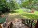 Lush backyard showing off the green lawn, swing set, garden and surrounding mature trees at 4114 Falcon Shores Nw Ct, Acworth, GA 30101