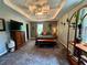 Bright bedroom with a tray ceiling, a cozy bed, and a stylish display cabinet at 4114 Falcon Shores Nw Ct, Acworth, GA 30101