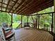 Relaxing covered deck with comfortable seating and views of the landscaped backyard at 4114 Falcon Shores Nw Ct, Acworth, GA 30101