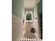 Stylish powder room with pedestal sink, wainscoting, and black and white tile floor at 4114 Falcon Shores Nw Ct, Acworth, GA 30101