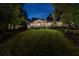 Evening view of the property, showcasing a well-manicured lawn, mature trees, and a serene, private backyard setting at 654 Cannon Rd, Sharpsburg, GA 30277