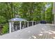 Backyard deck offers an outdoor grill and seating area surrounded by a lush, wooded landscape at 654 Cannon Rd, Sharpsburg, GA 30277