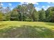 Expansive lawn offers ample space for recreation and outdoor activities, surrounded by mature trees at 654 Cannon Rd, Sharpsburg, GA 30277