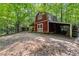 Rustic barn with a covered area for storage, set in a wooded location, offering potential for various uses at 654 Cannon Rd, Sharpsburg, GA 30277