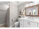 Well-lit bathroom featuring a white vanity with stone countertop, framed mirror, and walk-in shower at 654 Cannon Rd, Sharpsburg, GA 30277