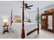 Spacious bedroom featuring a four-poster bed, antique armoire, and light-filled ambiance at 654 Cannon Rd, Sharpsburg, GA 30277