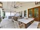 Covered deck featuring a dining table, seating area, ceiling fan, and decorative lighting at 654 Cannon Rd, Sharpsburg, GA 30277