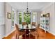 Bright dining room with wood floors, large windows, and a chandelier above the table at 654 Cannon Rd, Sharpsburg, GA 30277