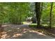 Long, winding driveway leading to a secluded home, surrounded by mature trees and landscaping at 654 Cannon Rd, Sharpsburg, GA 30277