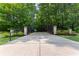 Gated entrance to a beautiful wooded property, featuring lush landscaping and a private driveway at 654 Cannon Rd, Sharpsburg, GA 30277