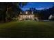 Inviting two-story home with a sprawling lawn, covered porch, and manicured landscaping at twilight at 654 Cannon Rd, Sharpsburg, GA 30277