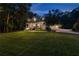 Beautiful two-story home at dusk, showcasing a covered front porch and lush, green landscaping at 654 Cannon Rd, Sharpsburg, GA 30277