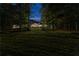 A home with large front lawn and mature trees, illuminated at night, offering a peaceful and inviting curb appeal at 654 Cannon Rd, Sharpsburg, GA 30277