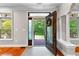 Inviting foyer featuring beautiful hardwood floors, decorative columns, and an ornate, glass-paneled front door at 654 Cannon Rd, Sharpsburg, GA 30277