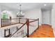 Upstairs hallway with hardwood floors and beautiful chandelier overlooking the foyer at 654 Cannon Rd, Sharpsburg, GA 30277