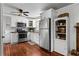 Well-lit kitchen with white cabinetry, stainless steel appliances, and hardwood flooring at 654 Cannon Rd, Sharpsburg, GA 30277