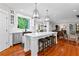 Open kitchen with island, stools, stainless steel appliances, and hardwood floors at 654 Cannon Rd, Sharpsburg, GA 30277