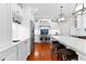 White kitchen featuring an island with seating, stainless steel appliances, and hardwood flooring at 654 Cannon Rd, Sharpsburg, GA 30277