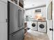 The laundry room features stainless steel appliances, a refrigerator, and ample storage in the white cabinets at 654 Cannon Rd, Sharpsburg, GA 30277