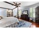 This expansive main bedroom features a four-poster bed, ceiling fan, and a cozy reading nook with bookshelves at 654 Cannon Rd, Sharpsburg, GA 30277