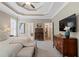 Spacious main bedroom showcasing tray ceilings, a TV, wooden furniture, and neutral decor at 1315 Woodland Trce, Cumming, GA 30041