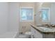 A clean, modern bathroom with granite counters, white cabinets, and white tiled walls at 1982 Yucca Dr, Decatur, GA 30032