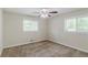 Inviting bedroom featuring neutral carpet, two windows, and a ceiling fan for comfort at 1982 Yucca Dr, Decatur, GA 30032