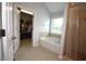 Main bathroom with soaking tub, tiled shower, and walk-in closet at 2311 Arnold Palmer Way, Duluth, GA 30096