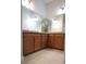 Bathroom features double vanity with wooden cabinets, granite countertops, and a large mirror at 2311 Arnold Palmer Way, Duluth, GA 30096