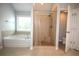Bright main bathroom with tiled shower, soaking tub and open doorway to toilet at 2311 Arnold Palmer Way, Duluth, GA 30096