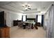 Bright main bedroom featuring a tray ceiling, carpet floors, and large windows with patterned curtains at 2311 Arnold Palmer Way, Duluth, GA 30096