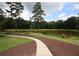 Pond in a well-maintained community with mature trees, green grass, and a walking path at 2311 Arnold Palmer Way, Duluth, GA 30096