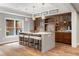 Entertaining bar area with counter seating and custom cabinetry, complemented by unique lighting at 2430 Flat Stone Dr, Cumming, GA 30041