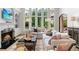 Elegant living room with fireplace, built-in shelving, and large windows overlooking yard at 2430 Flat Stone Dr, Cumming, GA 30041