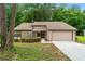 Charming single-Gathering home with a beige exterior and attached two-car garage, set amongst lush trees at 4818 Terrace Green Trce, Stone Mountain, GA 30088