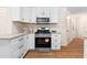 Well-equipped kitchen featuring stainless steel appliances, granite countertops, and wood-look flooring at 4818 Terrace Green Trce, Stone Mountain, GA 30088